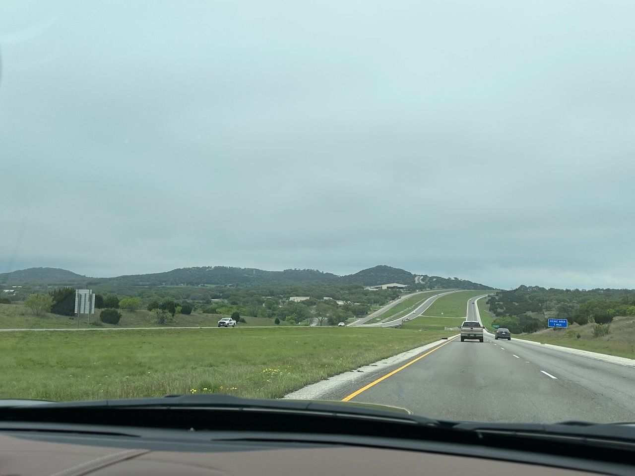 The wide layout of I-10 stretches down a hill and up the next, curving to the right at the top of the hill.